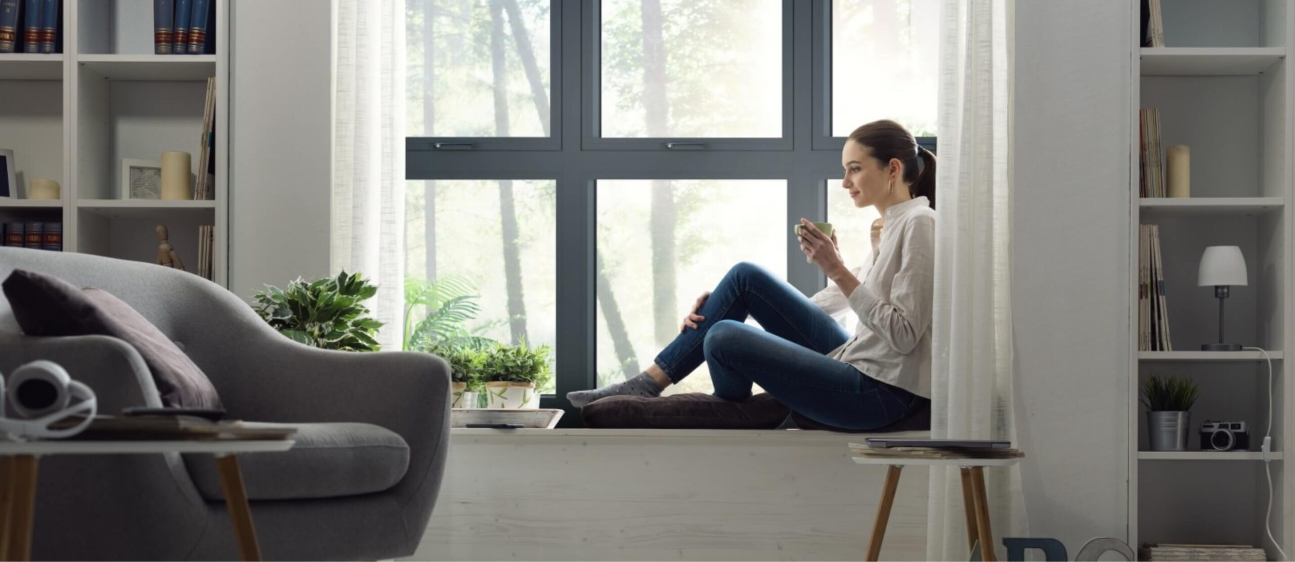lady sitting on window pane sipping coffee